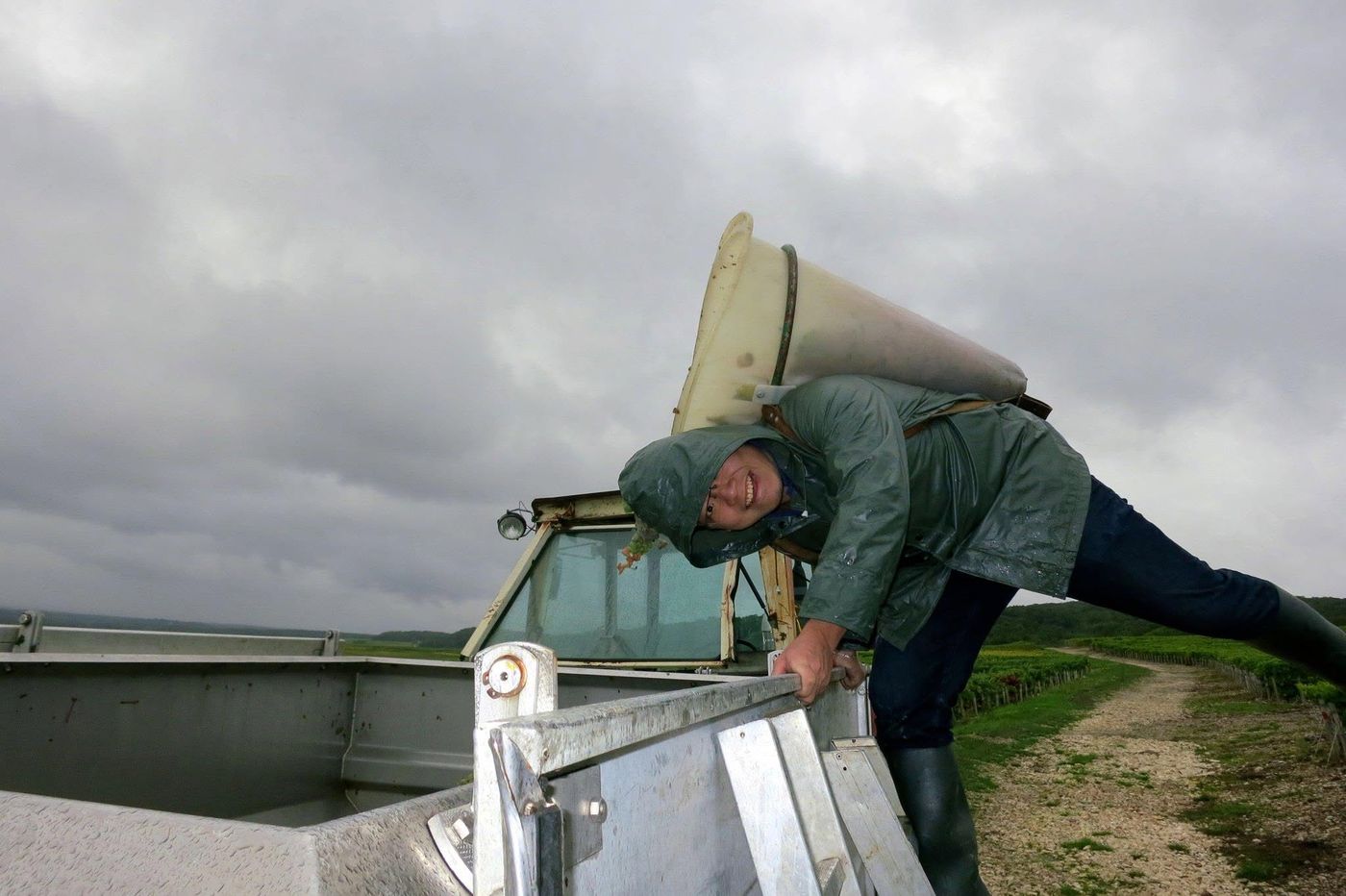 Tipping a full hotte into the trailer under a storm sky
