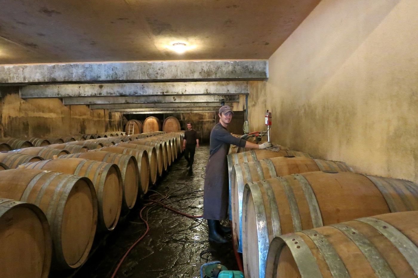 Washing barrels out with a hose in a wet cellar